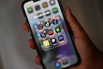 A-13-year-old-boy-poses-at-his-home-as-he-looks-at-social-media-on-his-mobile-phone-in-Sydney