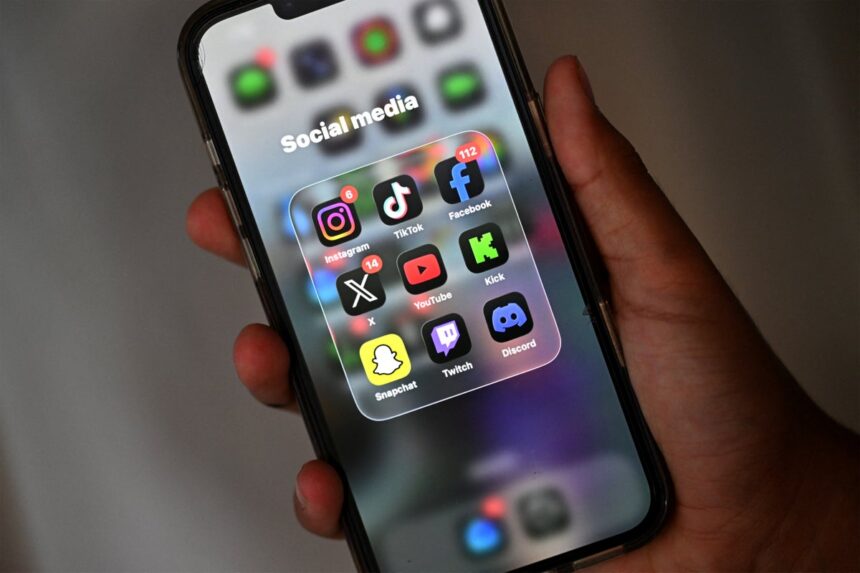 A-13-year-old-boy-poses-at-his-home-as-he-looks-at-social-media-on-his-mobile-phone-in-Sydney